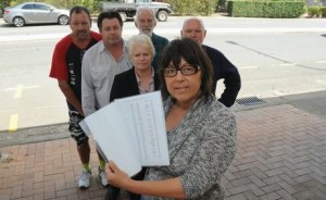 In countries like England and Australia, it is common for community members and clinical laboratory worker unions to protest announcements that pathology laboratories in the region are to be closed and medical laboratory services are to be consolidated or restructured. Such changes are the result of budget cuts and pressures to cut costs in healthcare delivery. Pictured above are community members in Australia holding a petition to save the Maryborough Base Hospital pathology lab from a planned closure. (Photo by Megan Pope and copyright the Fraser Coast Chronicle.)