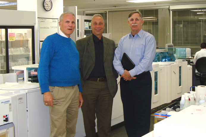 Here is the high-volume core chemistry laboratory at the flagship lab facility of Calgary Laboratory Services. From L: Leland B. Baskin, M.D., Ph.D. (who is Medical Director and Vice President of Medical Operations), Dale Gray (who is the Vice President of Technical Operations), and Robert Michel, Dark Daily editor.