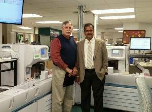 Scott & White Memorial Hospital in Temple, Texas, is a 636-bed specialty care and teaching hospital and Level I trauma center. Clinical laboratory services for that region of the BaylorScott and White Health system are consolidated at this hospital. Pictured above in the automated laboratory is Robert L. Michel (left), Editor-in-Chief of The Dark Report, and Amin Mohammed (right) Ph.D., DABCC, FACB. He is Professor of Pathology, Medical Director of the Pathology Informatic Center, and Clinical Chemist at Baylor Scott & White Healthcare. Mohammed was chair of the program committee for last Friday’s one-day conference conducted by the Texas Region of the American Association of Clinical Chemistry. (Photo copyright The Dark Report)