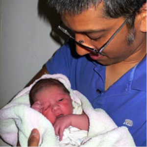 Razib Khan holds his infant son, the first person to be born in the United States with his entire genetic makeup deciphered. (Photo copyright MIT Technology Review)