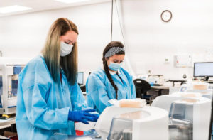 medtechs in pathology laboratory wearing blue gowns