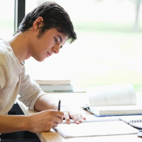 Serious Male Student Writing in a Laboratory